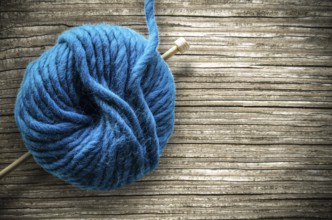 Retro Style Image Of A Ball Of Wool And Knitting Needle On A Rustic Wooden Table