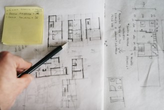 Man architect drawing plan or design by pencil on paper at office desk