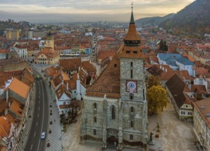 Aerial view of Brasov old town with Black Church and Piata Sfatului square in autumn morning,