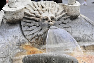 Stone fountain with face sculpture from which water flows, Rome, Lazio, Italy, Europe