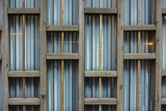 Wooden structure on the back of a metal fence