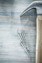 Vertical image of claw hammer nails on wooden board construction concept