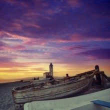Cabo de Gata in Almeria at San Miguel Beach and Salinas church with stranded boats at sunset