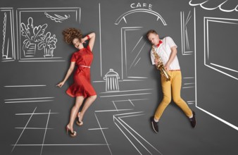Love story concept of a romantic couple against chalk drawings background. Male playing the