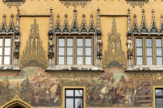 Painted façade and windows with 4 medieval human sculptures on Ulm Town Hall from the 15th century,