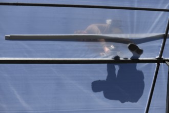 GREYMOUTH, NEW ZEALAND, DECEMBER 12, 2018: A tradesman is seen in silhouette as he secures the
