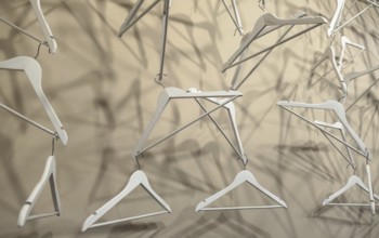 Empty wooden clothes hangers casting deep shadows. Real coat hanger wood pattern. Abstract fashion