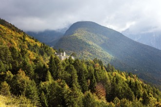 Travel to Slovenia. Ruins of a medieval castle on a mountainside. The mountain road passes through