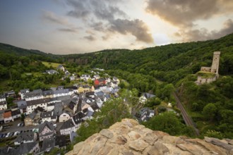 Landscape of a half-timbered village on a river, surrounded by hills and a castle. Beautiful nature