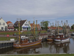Fishing boats are anchored in the harbour, in the background houses and a maritime atmosphere,