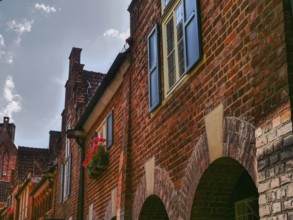 A street with historic brick houses, blue shutters and flower boxes, Bremen, Germany, Europe