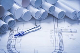 Pair of compasses with blueprint rolls building and architecture concept