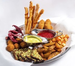 Large plate with a wide selection of snacks for beer served with two kinds of sauce on a white