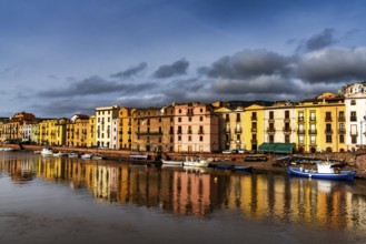 Bosa, Italy, 13 December, 2022: colorful houses and fishing boats on the waterfront of Bosa on the