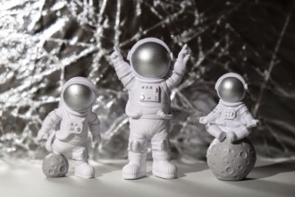 Three Plastic toys figure astronaut on silver background Copy space. Concept of out of earth