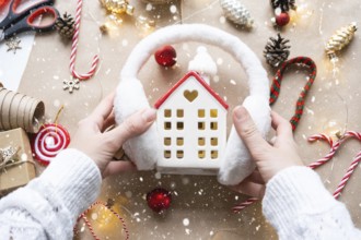 Cozy house in Christmas decor layout, warm knitted scarf, hat, winterization. Winter, snow, home