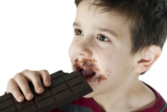 Smiling kid eating chocolate. Smeared stained with chocolate lips. White isolated