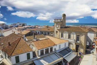 Orange and yellow tiled roofs of Provencal city Saintes-Maries-de-la-Mer. Mediterranean Sea. The