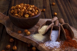 Roasted spicy chickpeas with salt, garlic and paprika on rustic background