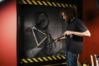 Services professional washing of a bicycle in the workshop. Close-up of hand Young Caucasian