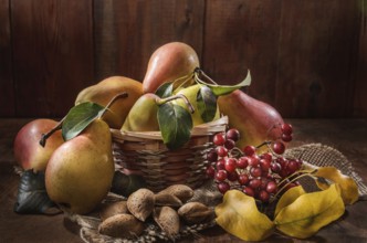 Ripe pear and a bunch of viburnum berries on a dark wooden background in a rustic style