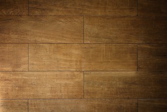 Warm light illuminating textured brown wooden floor tiles, creating a rustic and inviting ambiance
