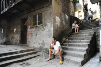 04.08.2012, Chongqing, China, Asia, Men sit on the steps in front of an old house in the old town