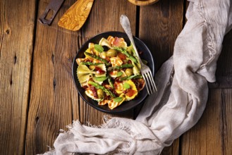 Pasta salad with green asparagus, olives and Parma ham