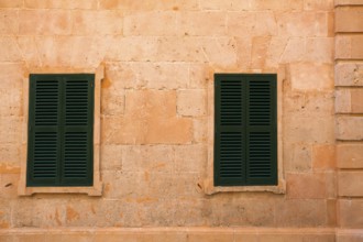 Ciutadella Menorca wooden shutter window on grunge yellow downtown wall at Balearic islands