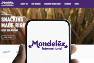 Mondelez international logo is displayed on smartphone. Mondelez International is an American