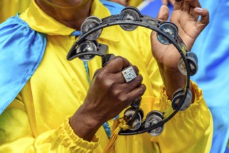 Tambourine player in colorful clothes during a performance at a traditional Brazilian religious