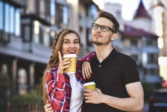 Portrait of happy couple walk on the street with coffee