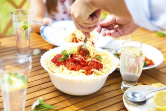 Family dinner variety of Italian dishes on wooden table in the garden