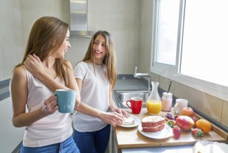 Best friends girls teens breakfast in kitchen having fun