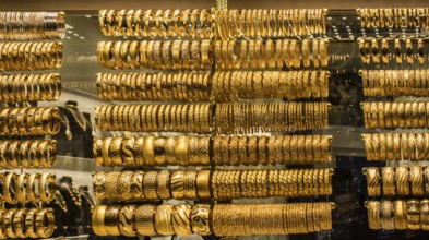 Shop display of dozens of golden bracelets and bangles