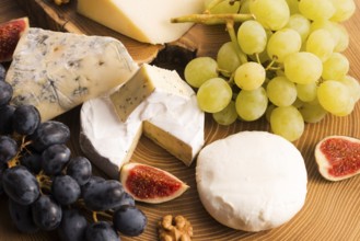 Assortment of cheese with fruits and grapes