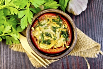 Fish baked in tomato in Zandvoort in clay bowl on a napkin of burlap, parsley on a dark wooden