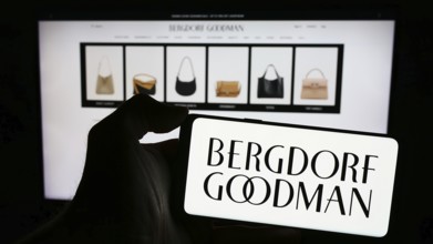 Stuttgart, Germany, 02-26-2024: Person holding cellphone with logo of US luxury department store