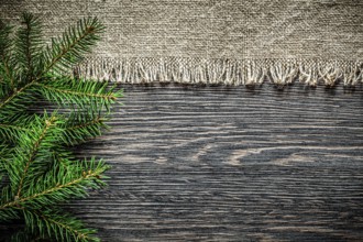 Vintage burlap pine branch on wooden board Christmas background