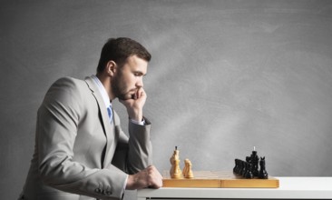 Businessman moving chess figure in chessboard. Successful management and leadership. Handsome man