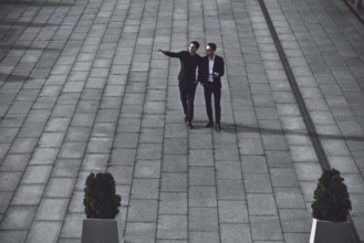 Portrait of two businessmen discussing about the new project while walking outdoors