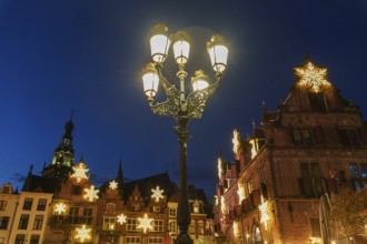 Stylish street lantern in front of festively decorated historic facades at night, nijmegen, the