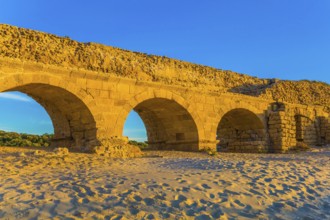 Stunning sunset on the Mediterranean coast in Israel. Well-preserved aqueduct, built in Caesarea at