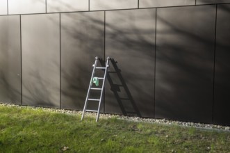Cleaning crew equipment left on grass lawn in front of modern architecture building facade during