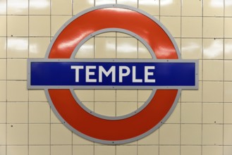 The red and blue Tube logo of Temple Station on a tiled background, London, London region, England,