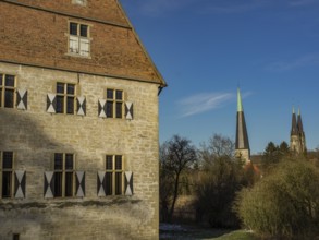 Historic building with shutters, and a church in the background on a clear day, billerbeck,