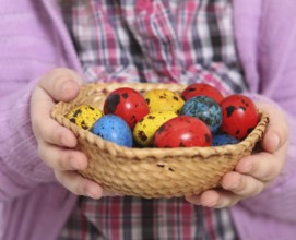 Cute little girl holding basket with easter eggs. Close up