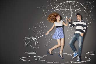 Happy valentines love story concept of a romantic couple in the rain against chalk drawings