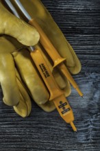 Set of electric tester safety gloves on vintage wooden board