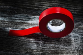 Rolled insulating tape on vintage wooden board